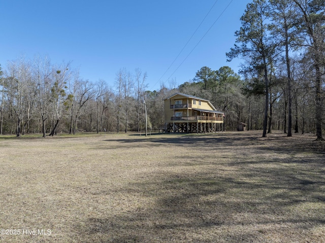 view of yard with a deck and a wooded view