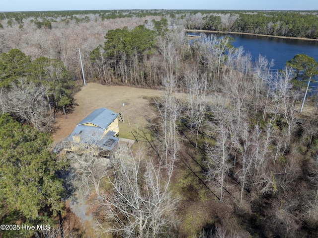 drone / aerial view featuring a wooded view and a water view