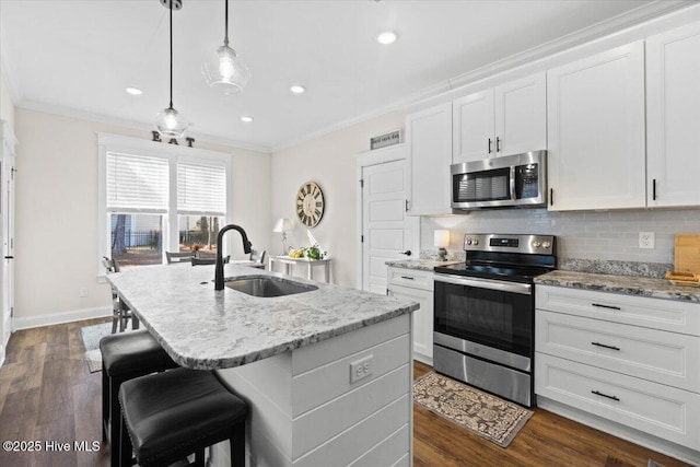 kitchen featuring a sink, decorative backsplash, appliances with stainless steel finishes, and ornamental molding