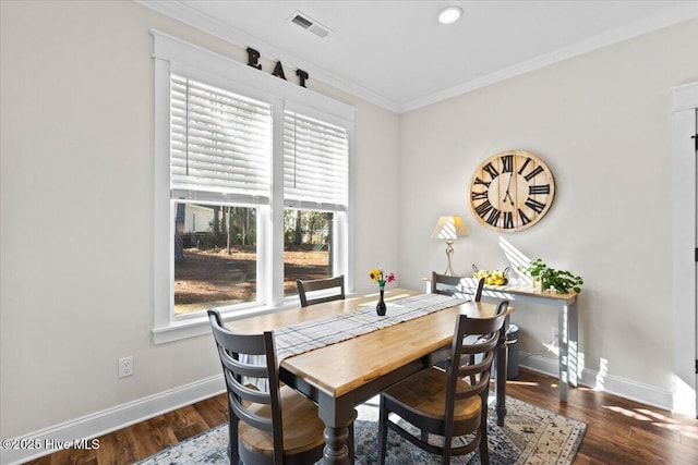 dining space with crown molding, baseboards, and wood finished floors