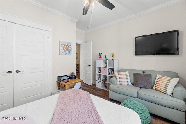 bedroom with dark wood finished floors, crown molding, a ceiling fan, and a closet