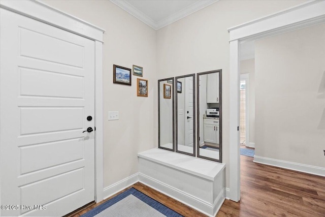 entryway featuring baseboards, wood finished floors, and ornamental molding