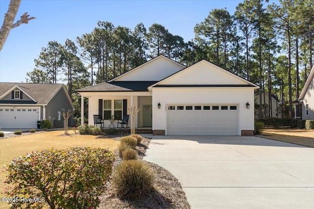 view of front facade with a porch, an attached garage, and driveway