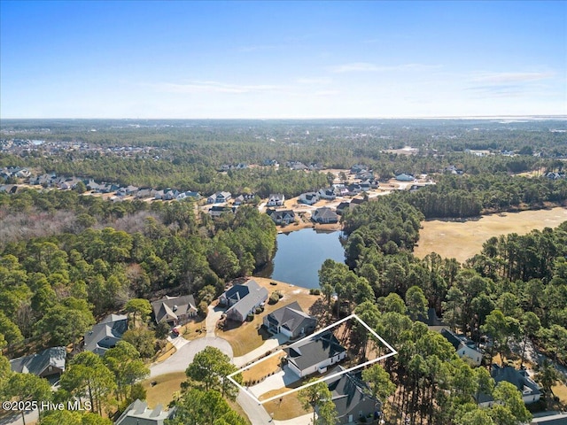 drone / aerial view with a forest view and a water view