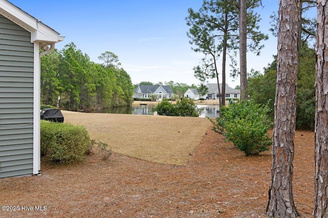 view of yard with a residential view and a water view