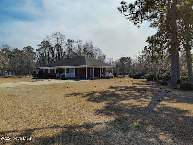 view of front of property with a carport, covered porch, and a front yard