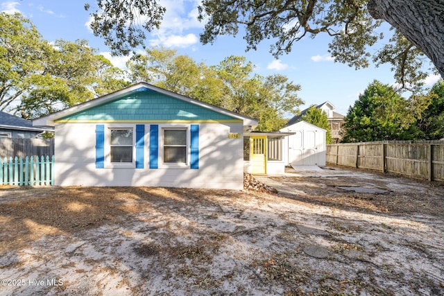 exterior space with an outbuilding, a storage shed, concrete block siding, and fence