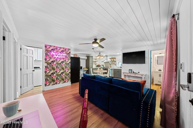 living area with crown molding, a ceiling fan, and light wood-type flooring