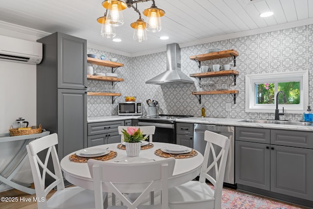 kitchen featuring open shelves, a sink, gray cabinetry, appliances with stainless steel finishes, and wall chimney exhaust hood