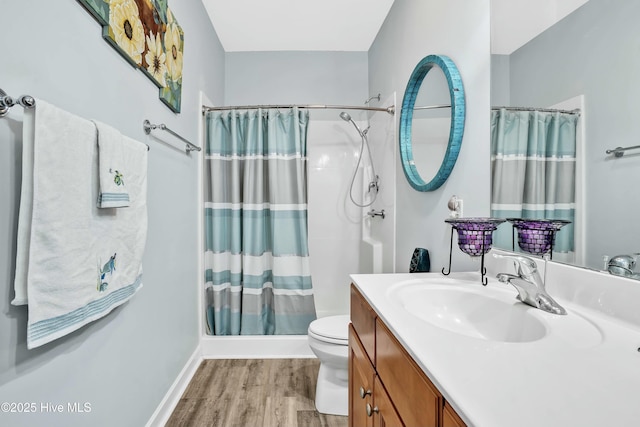 full bath with toilet, wood finished floors, a shower with shower curtain, baseboards, and vanity