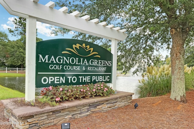 community sign with fence and a water view