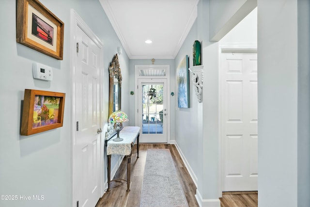 entryway featuring recessed lighting, crown molding, baseboards, and wood finished floors