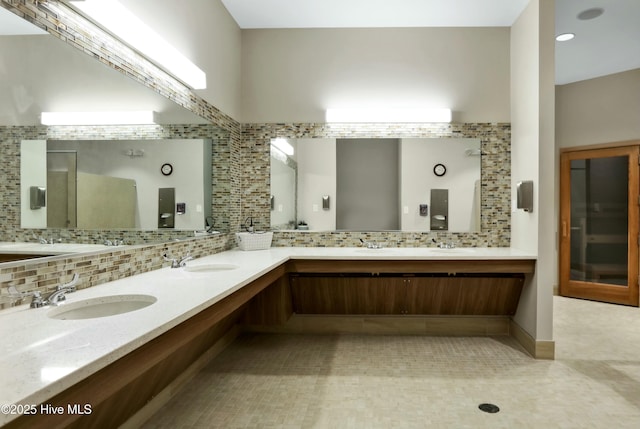 bathroom with double vanity, backsplash, and a sink