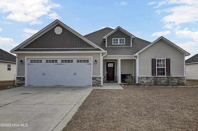 craftsman house with stone siding, an attached garage, concrete driveway, and roof with shingles