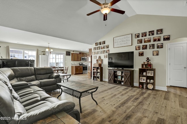 living room with high vaulted ceiling, light wood-style floors, baseboards, and ceiling fan