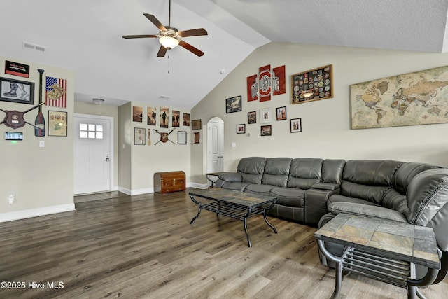 living area featuring arched walkways, vaulted ceiling, a ceiling fan, and wood finished floors