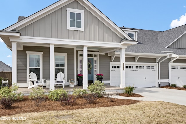 view of front of property featuring driveway, board and batten siding, covered porch, an attached garage, and a shingled roof