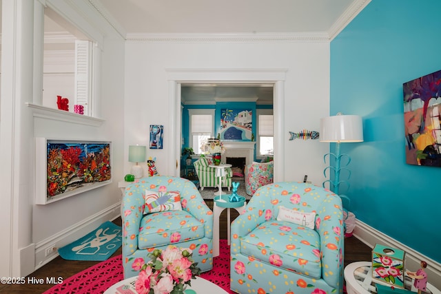 bedroom featuring a fireplace, wood finished floors, baseboards, and ornamental molding