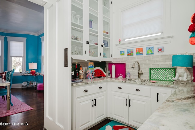 kitchen with dark wood-style floors, white cabinets, backsplash, and light stone countertops