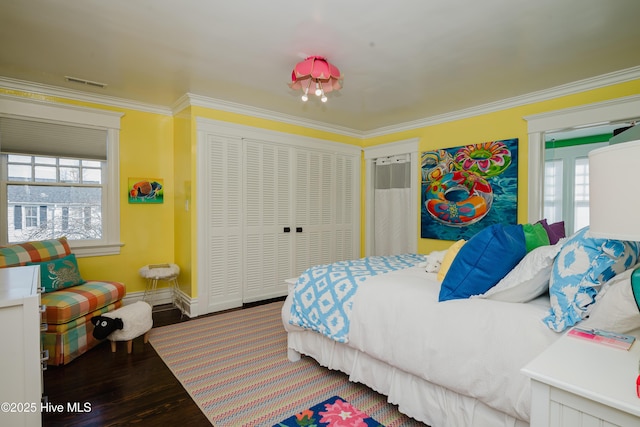 bedroom featuring multiple windows, wood finished floors, and ornamental molding