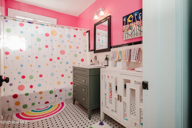 full bathroom featuring vanity, a shower with shower curtain, and tile walls