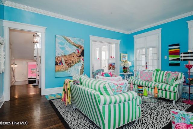 living area featuring crown molding, wood finished floors, baseboards, and a wealth of natural light