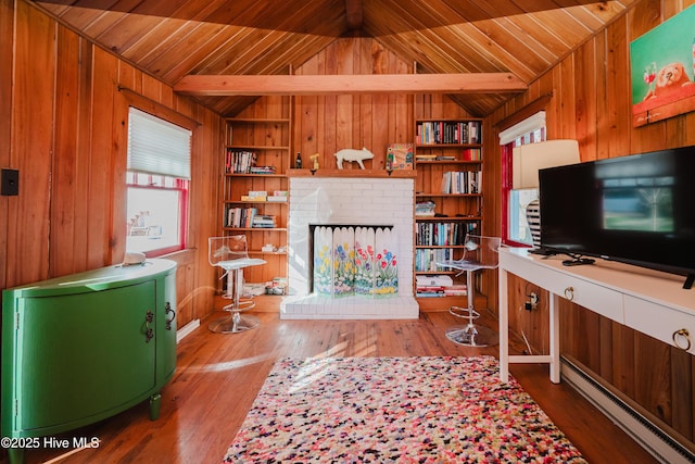 living area with wooden walls, built in shelves, a brick fireplace, lofted ceiling, and hardwood / wood-style floors