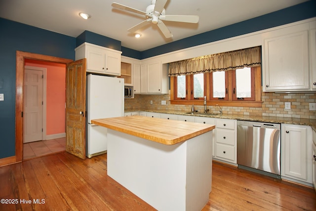 kitchen featuring a sink, open shelves, white cabinetry, stainless steel appliances, and wooden counters