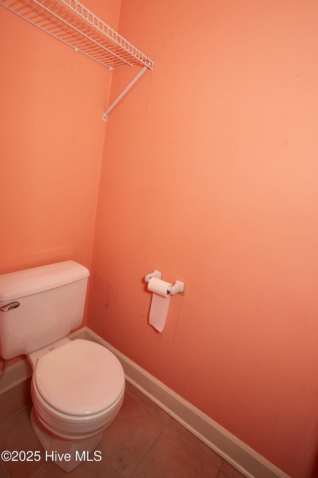 bathroom with tile patterned floors, toilet, and baseboards