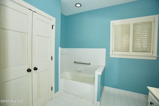 full bathroom with tile patterned floors, a closet, baseboards, and a garden tub