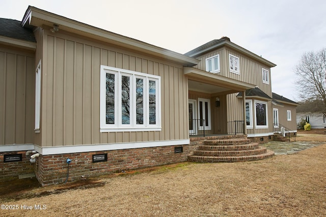 view of front of home featuring roof with shingles and crawl space