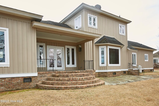 property entrance with crawl space, board and batten siding, and roof with shingles