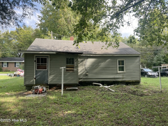 back of house with a lawn