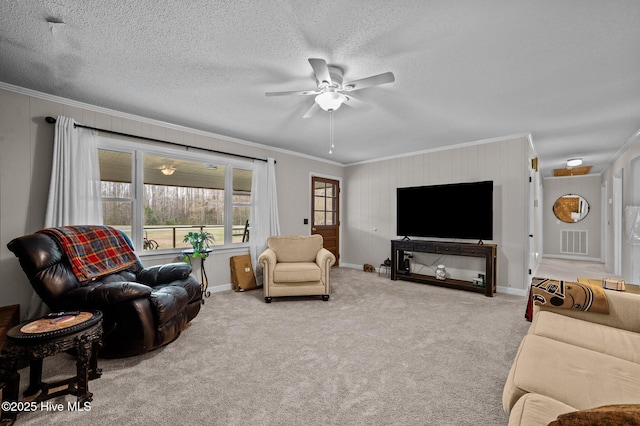 carpeted living area with visible vents, a textured ceiling, ceiling fan, and crown molding