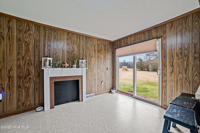 living area featuring wood walls, a fireplace, and a textured ceiling