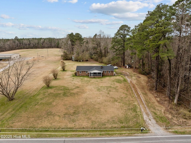 birds eye view of property featuring a view of trees