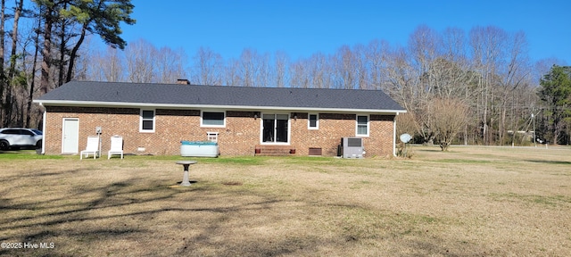 rear view of property featuring central air condition unit, a lawn, crawl space, brick siding, and a chimney