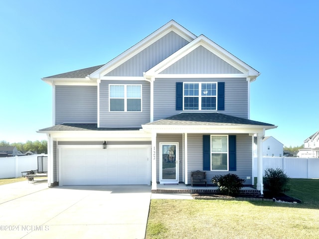 view of front of house with fence, a front yard, covered porch, a garage, and driveway