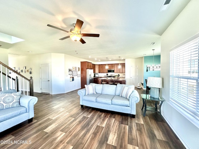 living room featuring visible vents, stairs, baseboards, and dark wood-style flooring