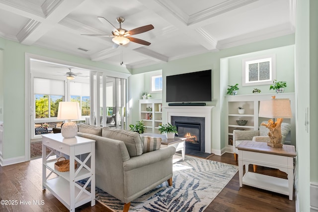 living room featuring a glass covered fireplace, coffered ceiling, ceiling fan, and dark wood finished floors