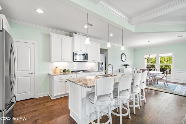 kitchen with a sink, dark wood-style floors, white cabinetry, stainless steel appliances, and decorative backsplash