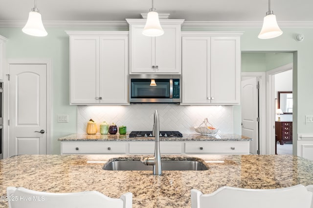 kitchen featuring a sink, appliances with stainless steel finishes, white cabinets, and crown molding