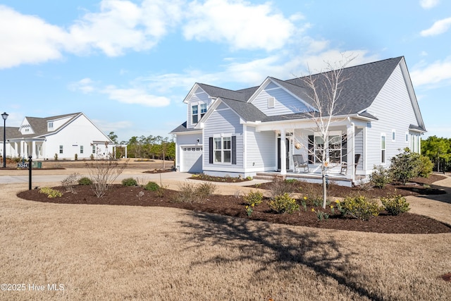 view of front of house featuring covered porch, driveway, and a shingled roof