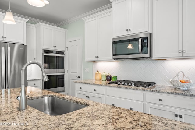 kitchen with a sink, crown molding, white cabinetry, and stainless steel appliances