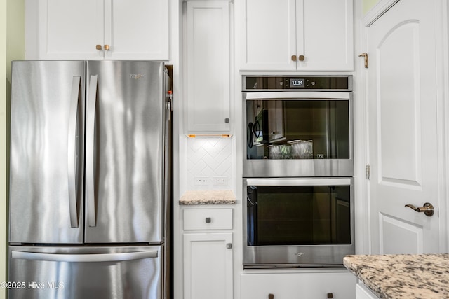 kitchen with white cabinetry, light stone countertops, tasteful backsplash, and appliances with stainless steel finishes