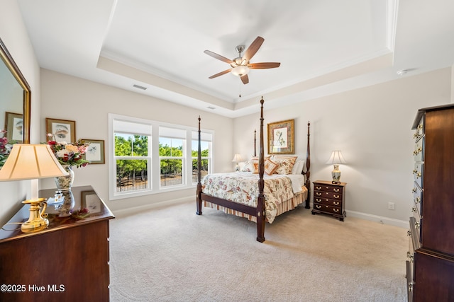 bedroom with visible vents, baseboards, ceiling fan, light colored carpet, and a raised ceiling