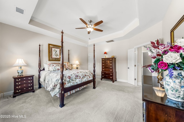 bedroom with light colored carpet, a raised ceiling, crown molding, and visible vents