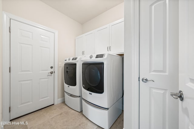 washroom featuring light tile patterned floors, cabinet space, and washing machine and dryer