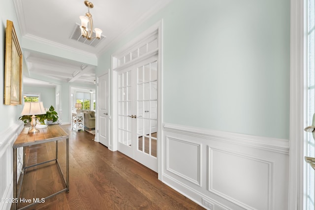 hall featuring visible vents, ornamental molding, coffered ceiling, dark wood finished floors, and a chandelier