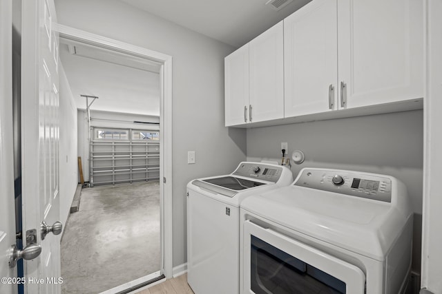 washroom with washer and clothes dryer, visible vents, cabinet space, and baseboards